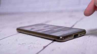 Kadın, Suşi siparişi vermek için akıllı telefondan İnternet Menüsünü tarıyor.