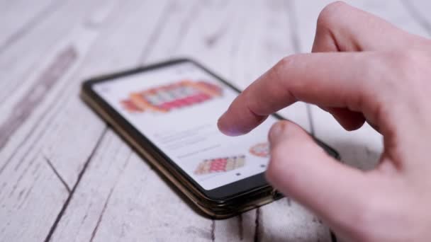 Femmina sta navigando il menu di Internet in uno smartphone per ordinare Sushi a casa — Video Stock
