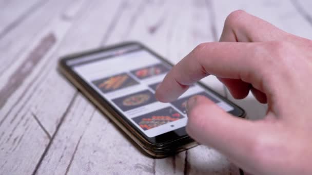 Mujer está navegando por el menú de Internet en un teléfono inteligente para pedir sushi en casa — Vídeos de Stock