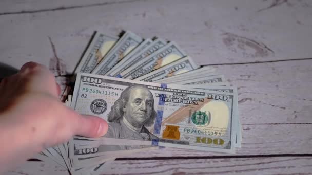 Kobieta Ręka Bierze stos Fanned Out 100 dolarów Bills Leżące na stole — Wideo stockowe