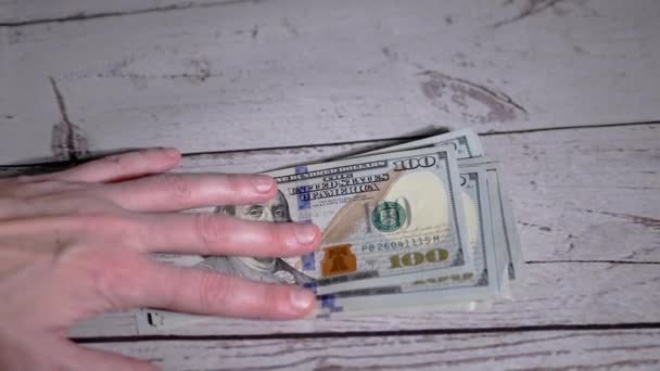 Жіночі руки, що викладають стопку 100 доларів, підраховують гроші. Повільний рух — стокове відео