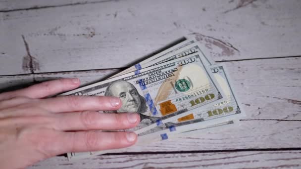 Manos femeninas extendiendo una pila de billetes de 100 dólares, contando dinero. Movimiento lento — Vídeo de stock