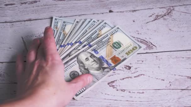 Female Hand neemt een stapel van Fanned Out 100 dollar Bills liggend op de tafel. 4K — Stockvideo