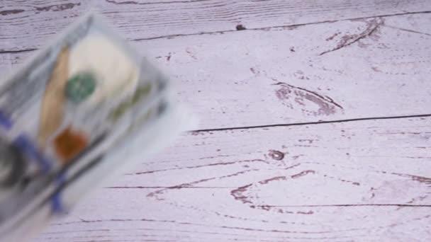 Женские руки бросают стопку банкнот в 100 долларов на стол. 4К. Медленное движение — стоковое видео