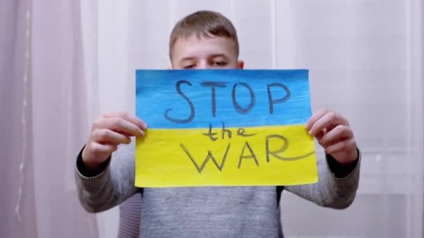 Child Holds in Hands a Poster with a Flag of Ukraine, és üzenet Stop the War — Stock videók