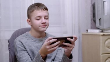 Çocuk sandalyede oturur, elinde bir akıllı telefon tutar, ekranda SMS okur. 4K