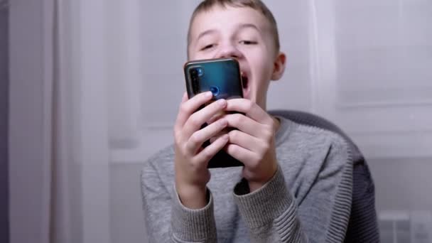 Нервно смеющийся Эмоциональный Ребенок тыкнул пальцем в экран смартфона. 4K — стоковое видео