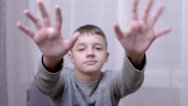 Triste enfant agitant les mains au revoir, bonjour, au revoir assis sur un fauteuil dans la chambre — Video