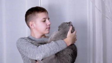 Gülümseyen Çocuk, Kucağında Yumuşak Bir Kedi Kucaklıyor, Odada Kol Sandalyesinde Oturuyor