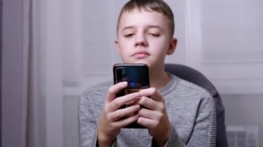 Gülümseyen Çocuk Sandalyeye Oturur, Akıllı Telefonu Ellerinde tutar, Ekranda SMS okur