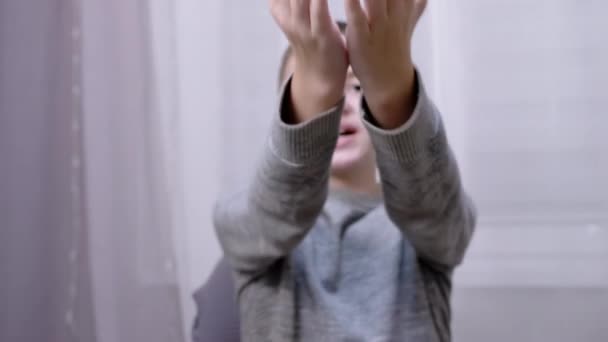 Веселий усміхнений кавказький хлопчик дме поцілунок, розтягуючи руку вперед — стокове відео