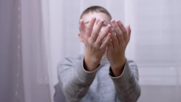 Vrolijk glimlachende blanke jongen blazen een kus terwijl het strekken van zijn hand naar voren — Stockvideo