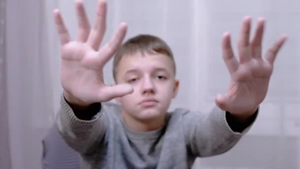 Triste niño saludando con las manos Adiós, Hola, Adiós mientras está sentado en un sillón en la habitación — Vídeos de Stock