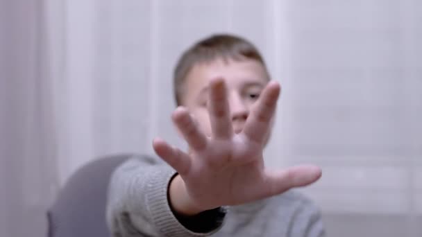 Triste criança acenando com as mãos Adeus, Olá, Adeus enquanto sentado em uma poltrona no quarto — Vídeo de Stock
