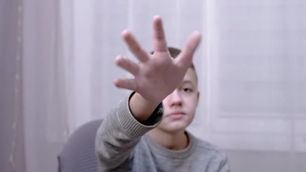 Triste bambino che saluta le mani Addio, Ciao, Ciao mentre siede su una poltrona in camera — Video Stock