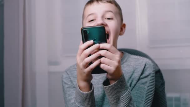 Nervózně se smějící emocionální dítě šťouchlo prstem do obrazovky chytrého telefonu. 4K — Stock video