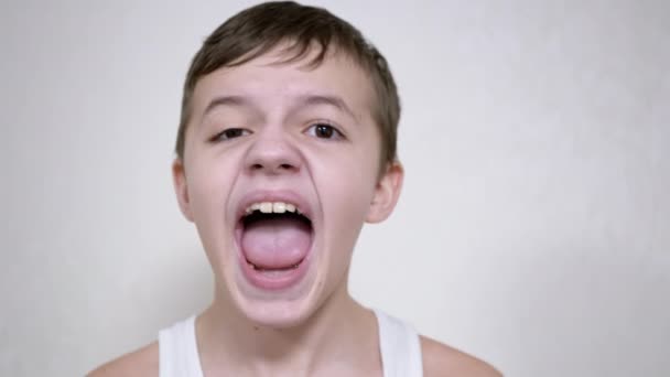 Το θυμωμένο παιδί ουρλιάζει δυνατά κοιτάζοντας την κάμερα. 4K. Κλείσε. — Αρχείο Βίντεο