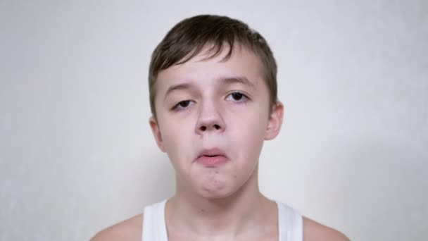 Knappe blanke jongen kauwgom die naar de camera kijkt. Een close-up. 4K. Langzame beweging — Stockvideo