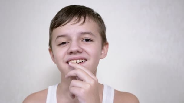 Glimlachende jongen kauwgom kijkend naar de camera. Een close-up. 4K. Langzame beweging — Stockvideo