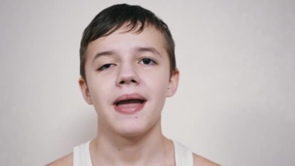 Smiling Teenager Gesticulates with Mouth, Showing his Teeth, Tongue. Tutup. — Stok Video