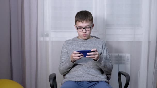 Gözlüklü Şaşkın Çocuk Smartphone 'da Mobil Uygulamada Video İzliyor. — Stok video