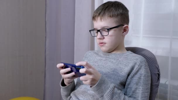 Serious Boy in Glasses Mówienie przez Smart Phone Online, Siedzenie na krześle. 4K — Wideo stockowe