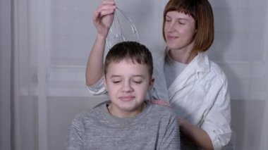 Masör, Kılcal Akupunktur Masajcısı ile Bir Çocuğun Başına Masaj Yapıyor