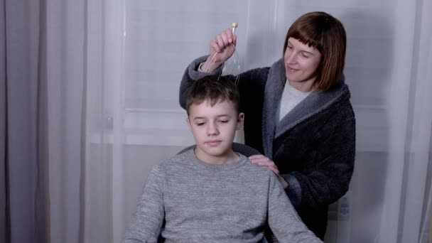 Mamina v županu masáže hlava dítěte s kapilární akupunkturní masážní — Stock video