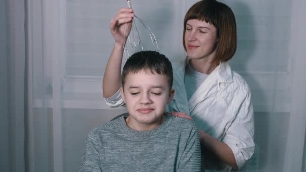 Massaggiatrice Massaggia la testa di un bambino con un capillare agopuntura Massaggiatore — Video Stock