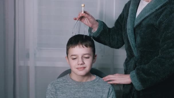 Weibliche Hand massiert den Kopf eines Kindes mit einem kapillaren Akupunktur-Massagegerät — Stockvideo