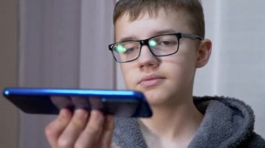 Gözlüklü Üzgün Çocuk Ellerinde Akıllı Telefon Tutuyor, Odadaki Video Bağlantısıyla Konuşuyor