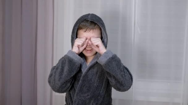 Brečící dítě si rukama s pěstmi tře oči. 4K. Zavřít — Stock video