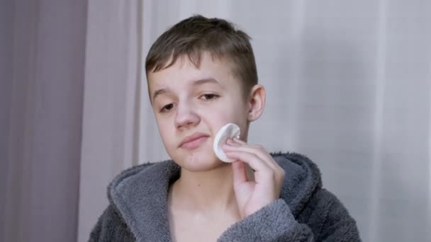 Разочарованный подросток чистит лицо от прыщей, используя хлопковую палочку. Zoom — стоковое видео