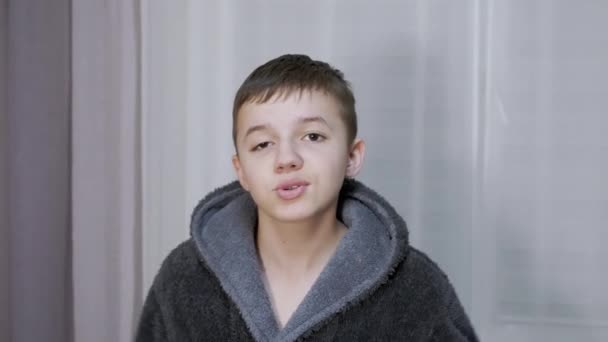 Boy in a Bathrobe Cheerfully Crying, Screaming, Talks, Looking at the Camera. 4K — Stock Video