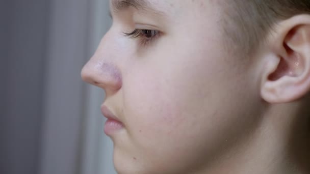 Лицевой профиль красивого подростка с пухлыми губами, длинными ресницами. Вид сбоку — стоковое видео