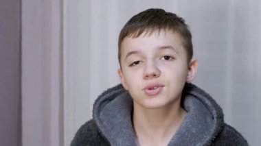 Bornozlu çocuk neşeyle ağlıyor, bağırıyor, konuşuyor, kameraya bakıyor.