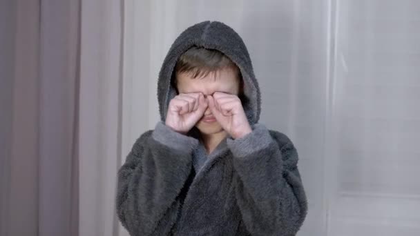 Huilend schreeuwend kind wrijft zijn ogen met zijn handen met vuisten. Zoom uit. Sluiten. — Stockvideo