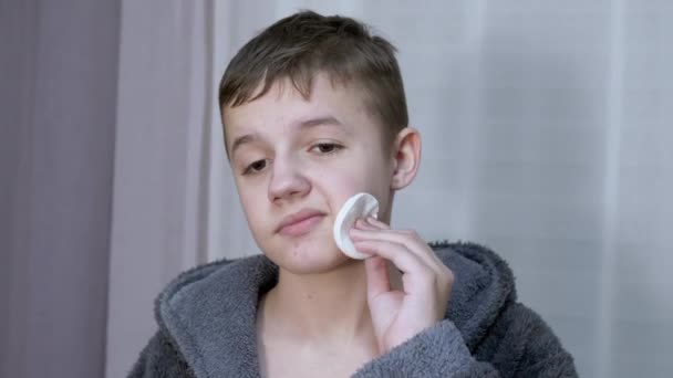 Разочарованный подросток чистит лицо от прыщей, используя хлопковую палочку. Zoom — стоковое видео