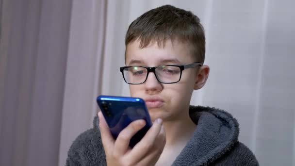 Gözlüklü Kızgın Çocuk Ellerinde Akıllı Telefon, Odada Video Bağlantısı ile Konuşuyor — Stok video