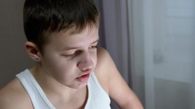 Öfkeli çocuk gergin bir şekilde bağırıyor, konuşuyor, yere bakıyor. Yakınlaştır. Kapat.