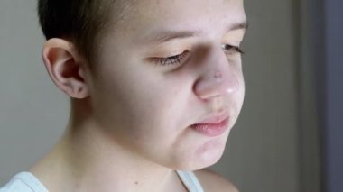 Gülümseyen bir gencin yüz profilinin yakından çekilmiş hali. Yan Görünüm