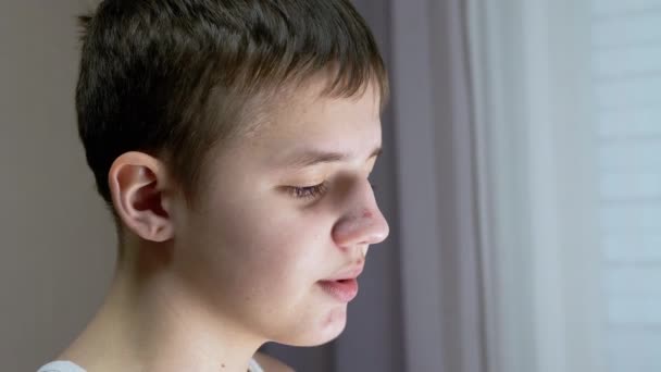 Close-up de um perfil de rosto de falar sorridente adolescente olhando para baixo. Vista lateral — Vídeo de Stock