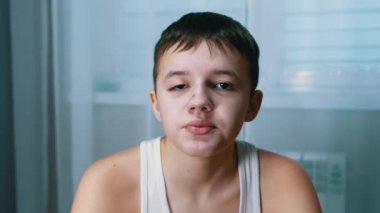 Kameraya bakan gülümseyen, konuşan bir gencin portresi. 4 bin. Kapat.