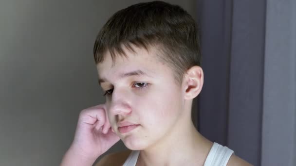 "Ansikt til en skyldig, trist tenåring med nedslått blikk". Se fra siden. 4K. Lukk – stockvideo