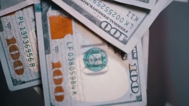 Beaucoup de billets américains de 100 dollars tombants et volants sur un fond flou — Video