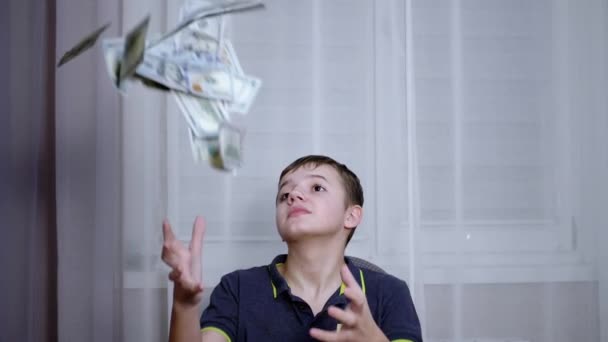 Šťastný teenager chycení s rukama padající 100 dolarů účty létání na jeho hlavu — Stock video