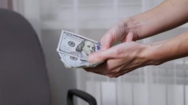 Kadın Eller 100 Dolarlık banknotları Kol Sandalyesi yakınındaki bir yelpazeye yayıyor