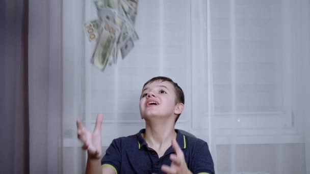 Šťastný teenager chycení s rukama padající 100 dolarů účty létání na jeho hlavu — Stock video