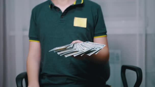 Bohaté dítě drží a mává balíčkem 100 dolarů bankovek ve svých rukou — Stock video