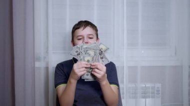 Gülümseyen Çocuk Kol Sandalyesinde otururken 100 Dolarlık banknotlar kazandı.